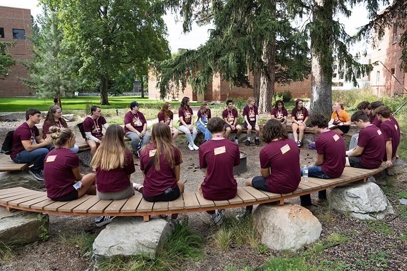 A group of students sit in a circle during an Orientation activity at UM