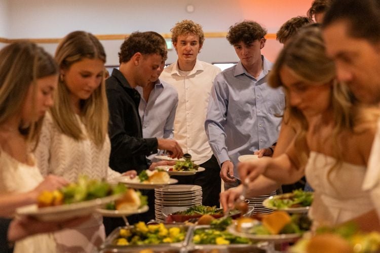 Friends gather around a food table