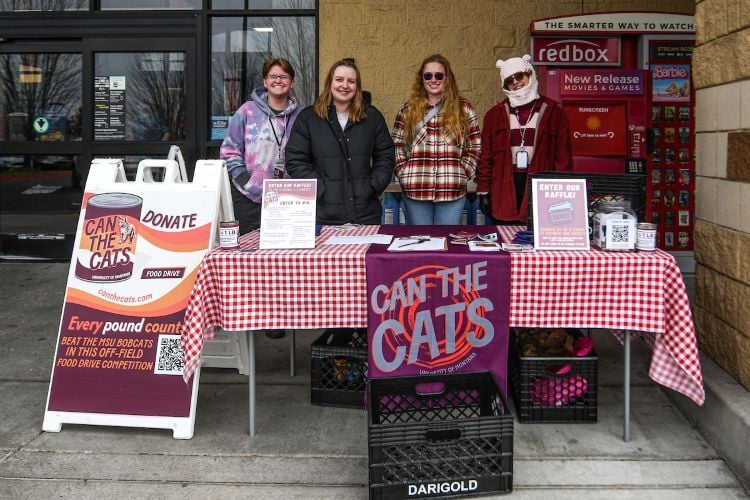A table set up outside a grocery store for the annual Can the Cats Food Drive
