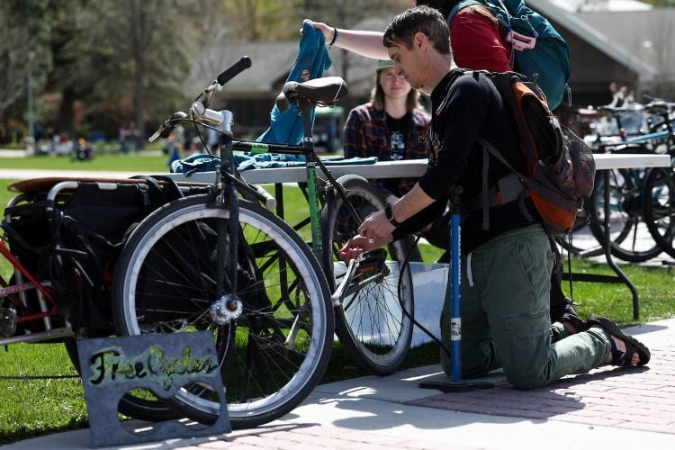 A student tunes up their bike on The Oval