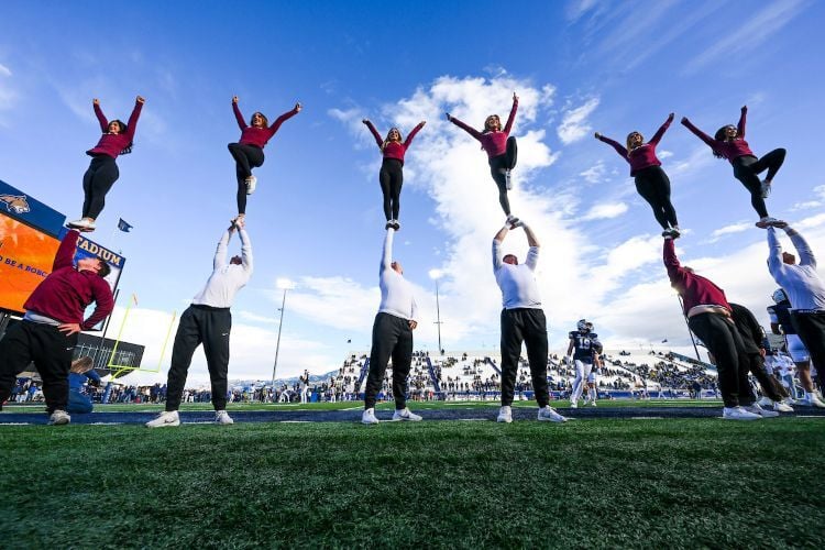 Grizzly cheerleaders holding each other up on game day