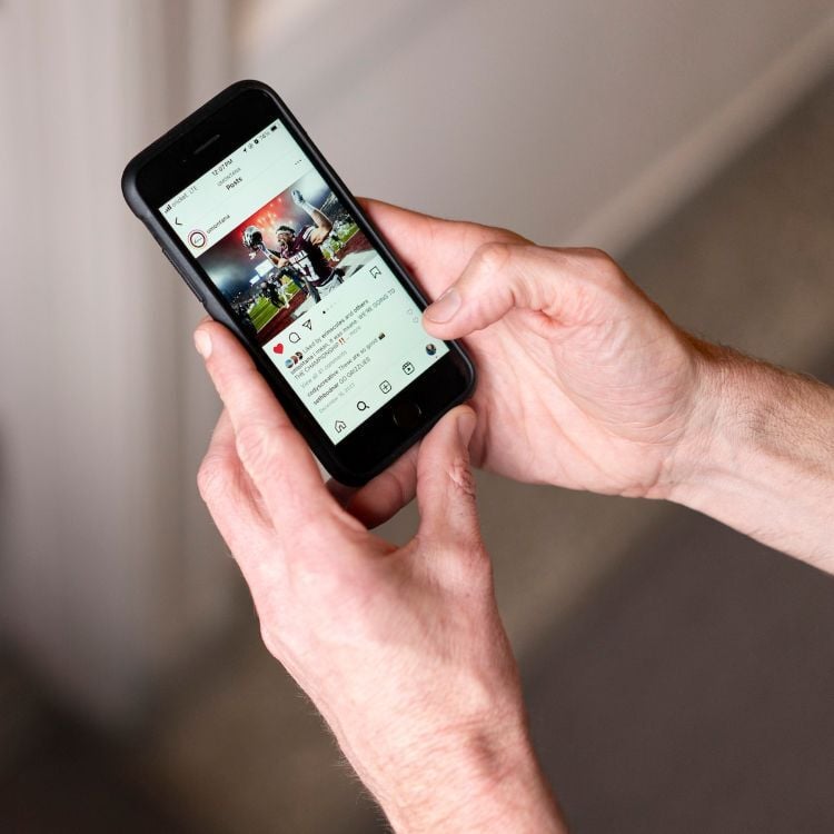 Person holding a phone and looking at instagram