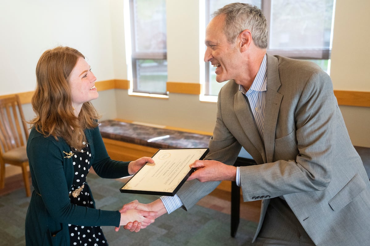 The Dean of the Davidson Honors College, Tim Nichols, shakes hands with an honors student