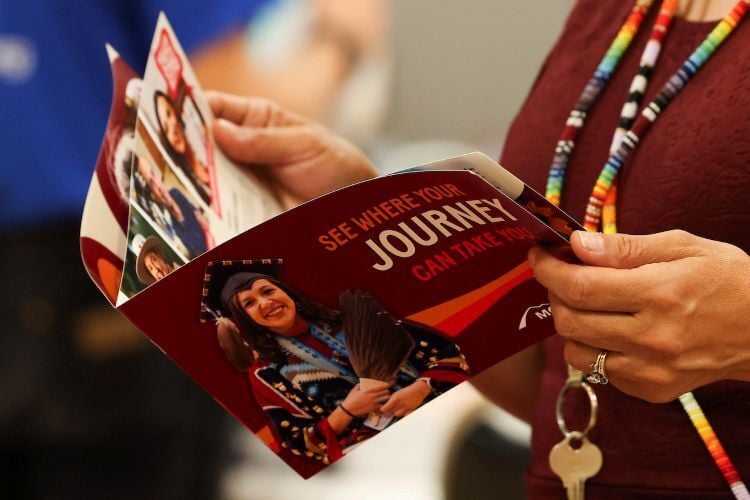 A student holding a UM pamphlet during a Griz Preview Day