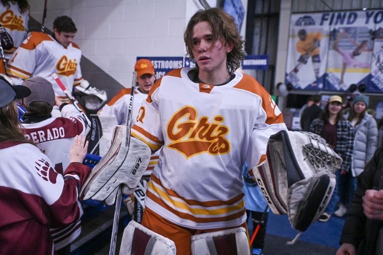 The goalie for UM's hockey team walking through a crowd of fans