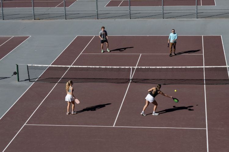 Students playing pickleball on a sunny day