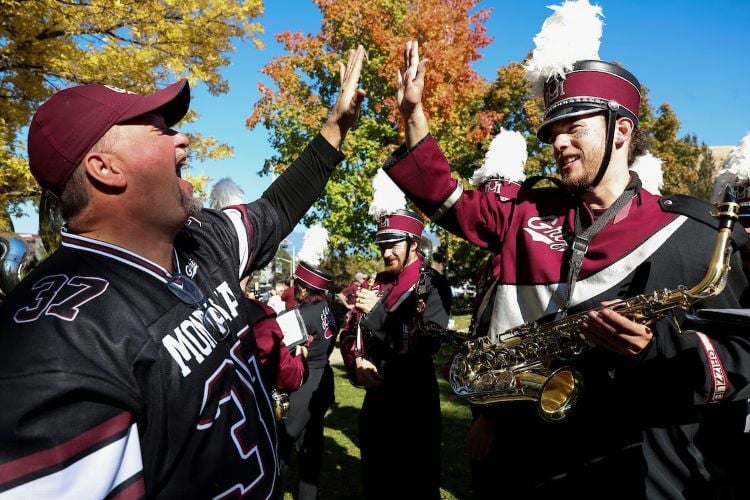 A member of Grizzly Marching Band high fives a Grizzly fan