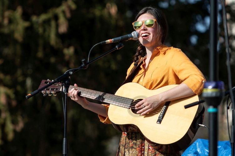 A student musician playing guitar on stage