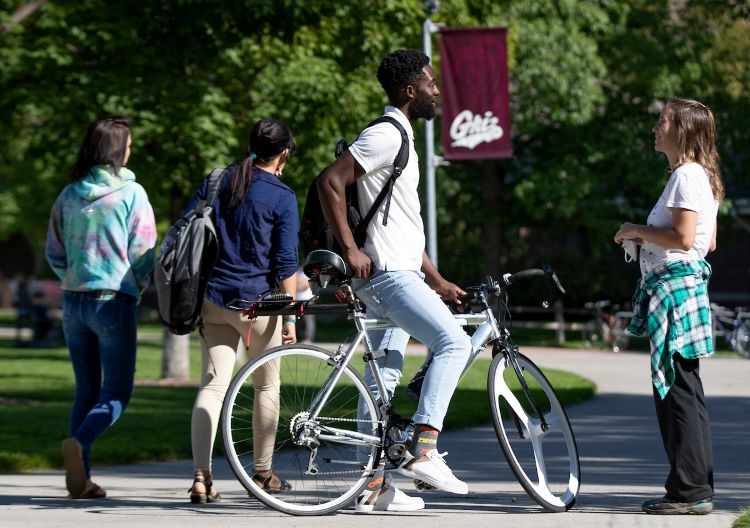 A student stops on The Oval on his bicycle