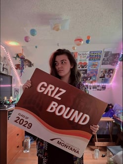 Author, Roo Gibson-Anderson, holds their Griz-bound sign