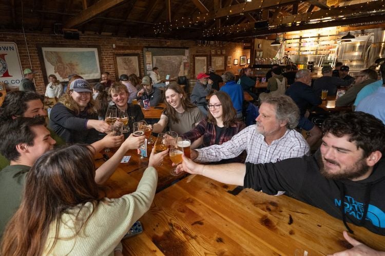 A large group of students cheersing across a table