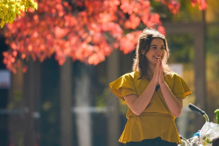 A student standing outside and smiling