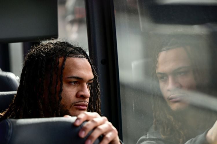 A student looks out of a window toward his own reflection