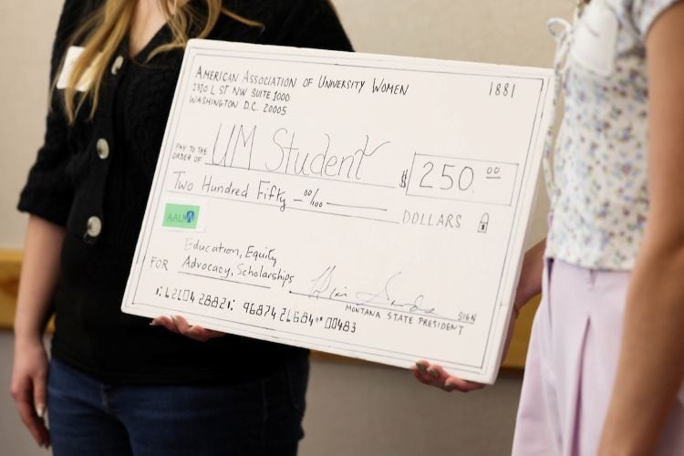 People holding up a large check for $250