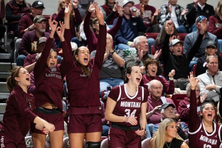 The Lady Griz basketball team cheers from their bench