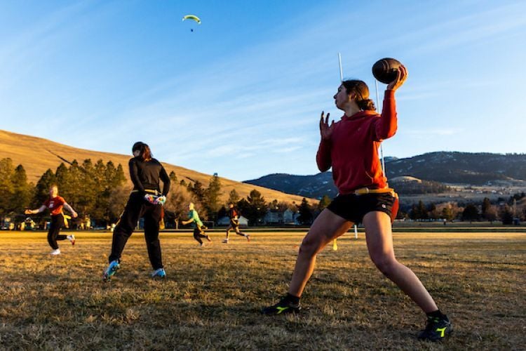Students playing flag football outside