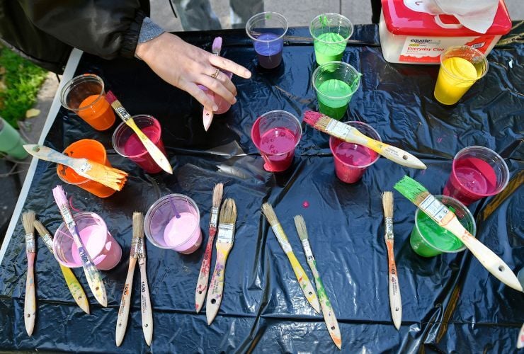 Cups of paint spread across a tarped table