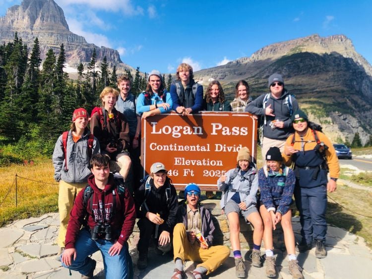 Students in the Park, Tourism and Recreation Management Program pose for a picture in front of Logan Pass at Glacier National Park.