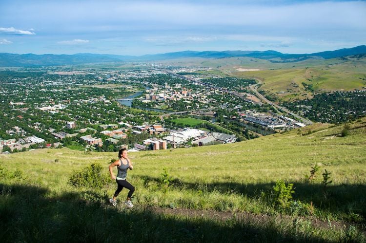 A runner ascending a mountain trail above town