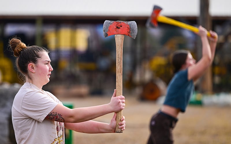A student prepares to throw an axe during a Forestry Club event