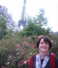 Professor Ione Crummy posing beneath the Eiffel Tower