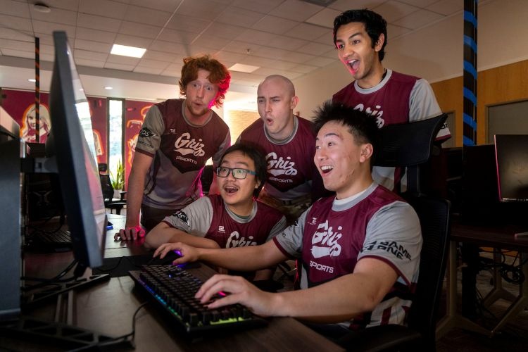 Members of esports gather around their gaming setup