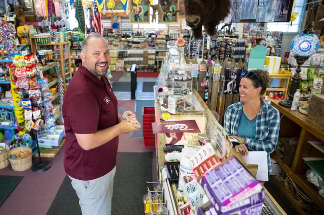 A UM employee standing at the cash register of the local Rockin' Rudy's store