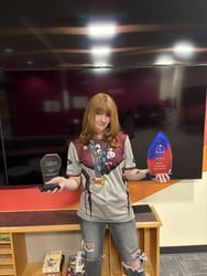 Esports athlete Bri Tilleman holding championship trophies
