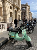 Scooters parked on a cobblestone Street in Amiens, France.