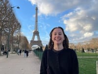 Author Madison Knapp standing in front of the Eiffel Tower