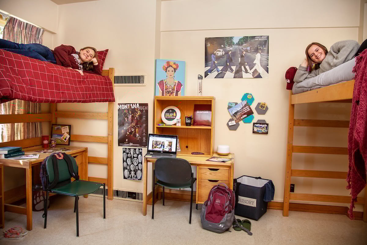 Two residence hall roommates atop their bunk beds